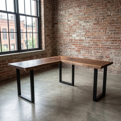 L-shaped solid wood corner desk with black steel legs in a brick-wall home office