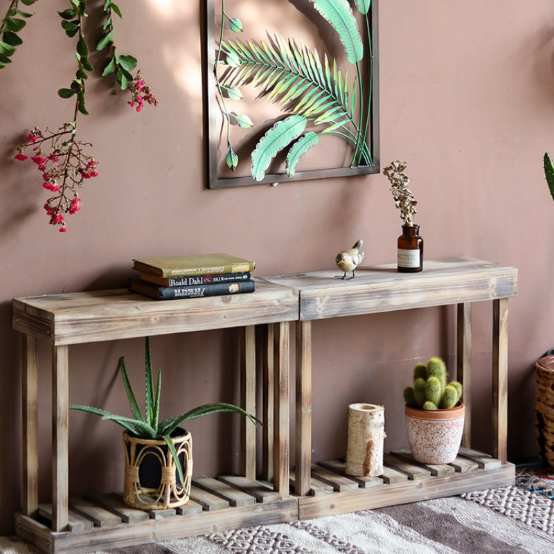 Wooden console table with decorative items against a pink wall