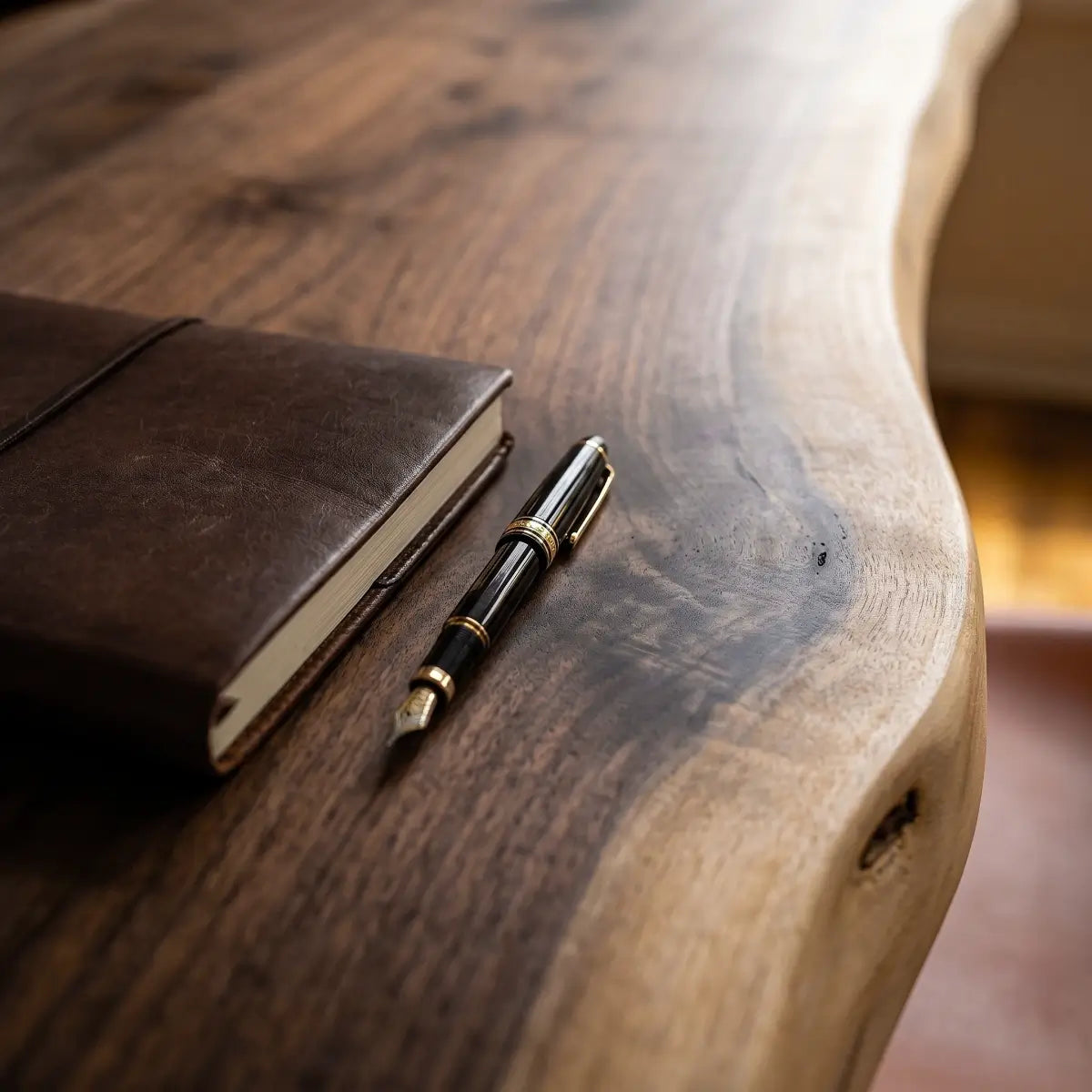Close-up of walnut-tone solid wood desk surface with natural grain and writing tools