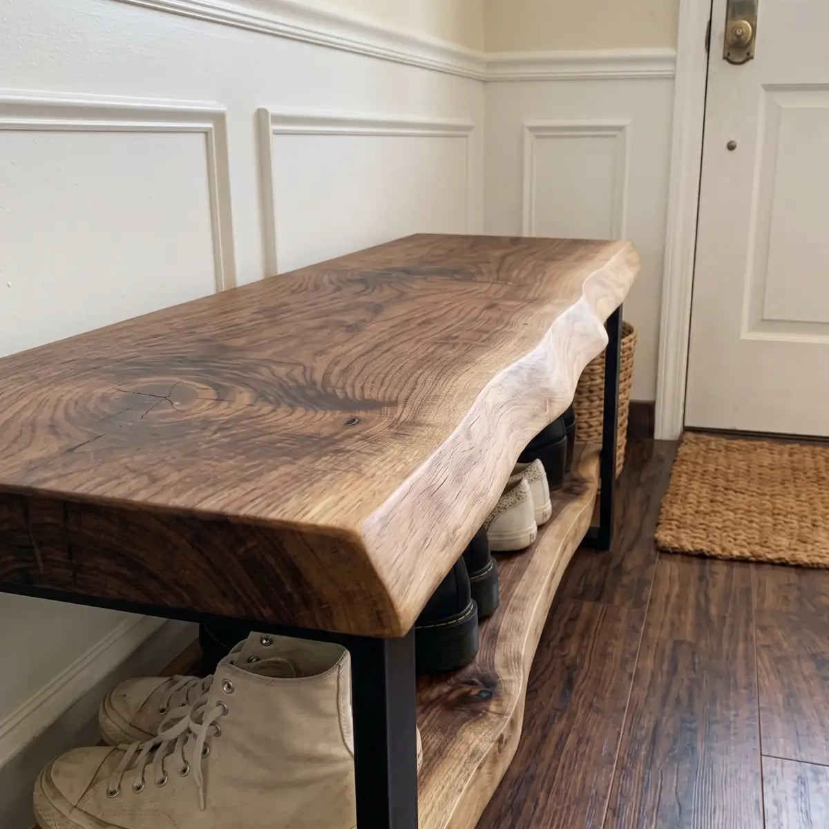 Angled close view of live edge wood bench showing natural grain, lower shoe shelf, and metal frame