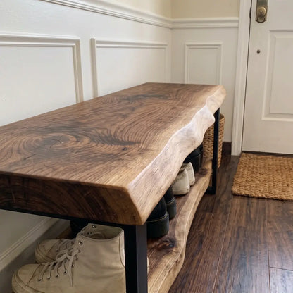 Angled close view of live edge wood bench showing natural grain, lower shoe shelf, and metal frame
