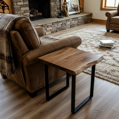 Solid wood live edge end table in walnut color finish beside armchair in living room with fireplace and cozy decor