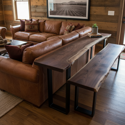 Solid wood live edge bench in walnut tone placed behind brown leather sofa with black steel legs